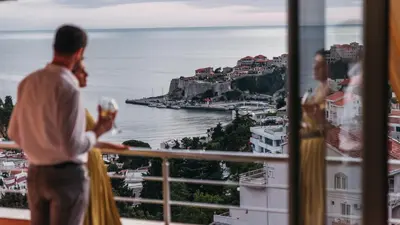 a group of people looking out a window at the ocean at Apartments Panorama Alaj in Ulcinj
