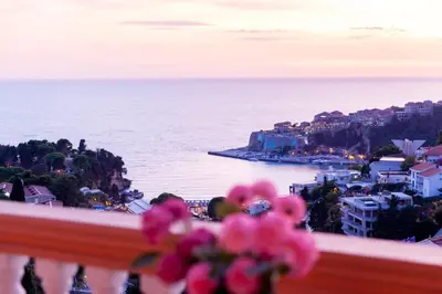 a view of the ocean from a balcony with pink flowers at Apartments Panorama Alaj in Ulcinj