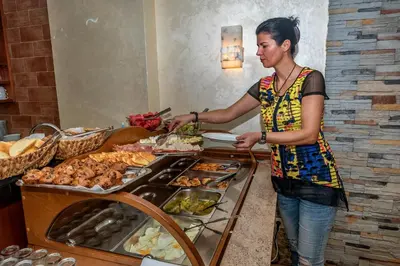 a woman is preparing food at a buffet at Villa Antivari in Bar