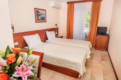 a hotel room with two beds and a balcony at Villa Antivari in Bar