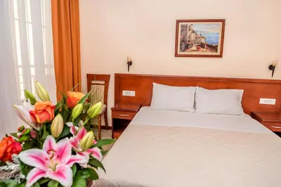 a bedroom with a bed and flowers in a room at Villa Antivari in Bar