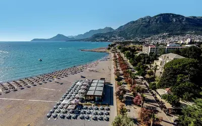 a beach with umbrellas and chairs and the ocean at Villa Antivari in Bar