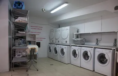 a laundry room with three washing machines in it at Apia Residence in Budva