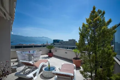 a patio with chairs and a christmas tree on a roof at Apia Residence in Budva
