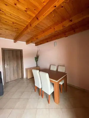 a dining room with a wooden table and white chairs at Apartments Vesna in Tivat