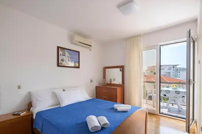 a bedroom with a blue bed with two towels on it at Apartments Bloom Bečići in Becici