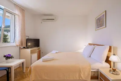 a small bedroom with a bed and a tv at Apartments Bloom Bečići in Becici