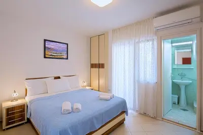 a bedroom with a bed and a bathroom with a sink at Apartments Bloom Bečići in Becici