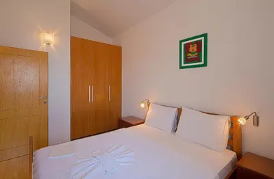 a bedroom with a white bed with a bow on it at Apartments Bloom Bečići in Becici