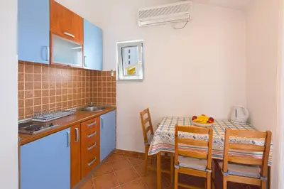 a small kitchen with a table and a table and chairs at Apartments Bloom Bečići in Becici