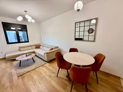 a living room with a couch and a table and chairs at Apartmants City Love in Podgorica