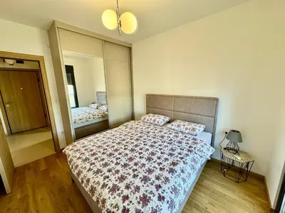 a bedroom with a bed and a large mirror at Apartmants City Love in Podgorica