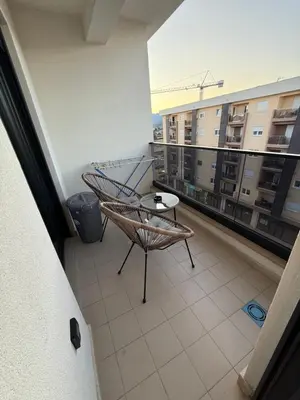 a balcony with a chair and a table on a building at Apartmants City Love in Podgorica