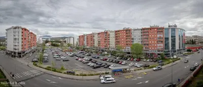 a city with cars parked in a parking lot at City kvart na dan in Podgorica
