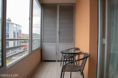 a balcony with two chairs and a table and a window at City kvart na dan in Podgorica