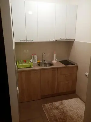 a small kitchen with a sink and white cabinets at City kvart na dan in Podgorica
