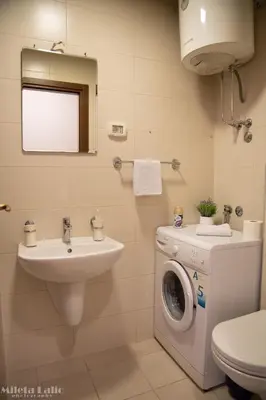 a bathroom with a washing machine and a sink at City kvart na dan in Podgorica