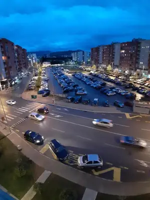 a parking lot full of cars in a city at night at City kvart na dan in Podgorica