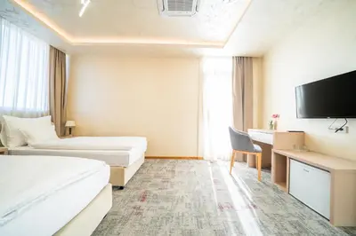 a hotel room with two beds and a flat screen tv at Hotel Alexandar Lux in Podgorica