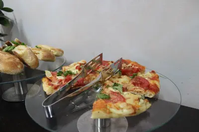 two plates of pizza on a glass table at Hotel Alexandar Lux in Podgorica