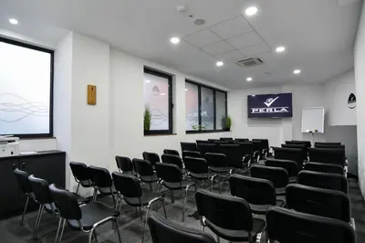 a conference room with chairs and a projection screen at Perla Residence Hotel & SPA in Podgorica