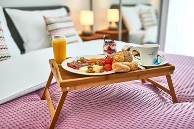 a tray with a plate of food on a table at Perla Residence Hotel & SPA in Podgorica