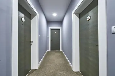 a hallway with blue walls and gray doors at Perla Residence Hotel & SPA in Podgorica