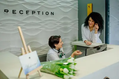 a woman talking on a cell phone in front of a mirror at Perla Residence Hotel & SPA in Podgorica