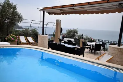 a swimming pool with a view of the ocean at Monte Perla Residence in Sveti Stefan