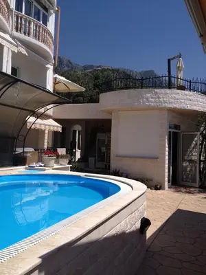 a swimming pool in front of a house at Monte Perla Residence in Sveti Stefan