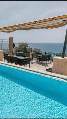 a swimming pool with a table and an umbrella at Monte Perla Residence in Sveti Stefan