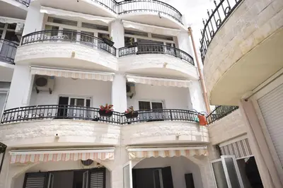 an apartment building with balconies on a street at Monte Perla Residence in Sveti Stefan