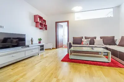a living room with a couch and a tv at Charming City Center in Podgorica