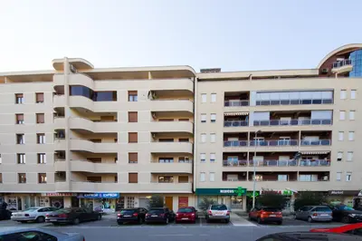 a parking lot with cars parked in front of a building at Charming City Center in Podgorica