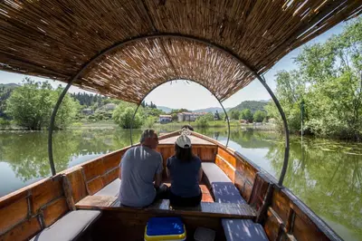 a man and woman sitting in a boat on the water at Vida`s house in Virpazar