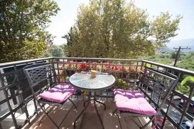 a table and chairs on a balcony with flowers at Vida`s house in Virpazar