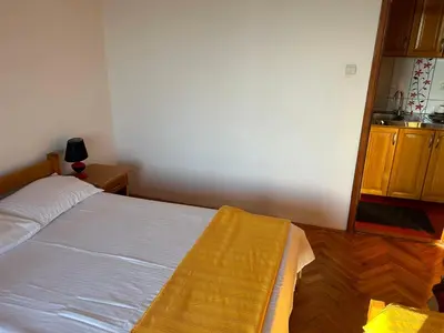 a bedroom with a bed with a yellow blanket on it at Apartments Djulija in Sutomore