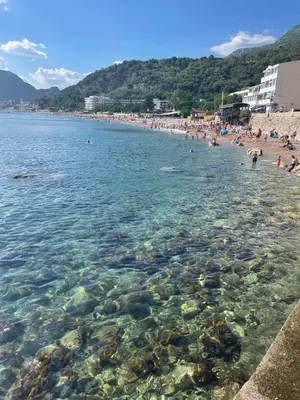 a beach with a bunch of people in the water at Apartments Djulija in Sutomore