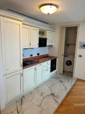 a kitchen with white cabinets and marble counter tops at Apartments Krug in Budva