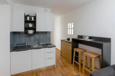 a kitchen with white cabinets and a sink at Apartments Krug in Budva