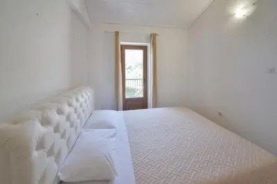a white bed in a room with a window at Kazanegra Exclusive Apartments in Sveti Stefan
