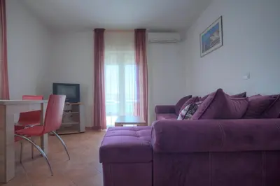 a living room with a purple couch and a table at Apartments Đurašević in Sveti Stefan
