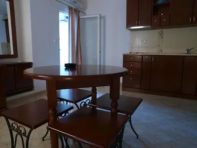 a kitchen with a table and chairs in a room at Apartments Obala B&B - Dragović in Petrovac na Moru