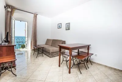 a living room with a table and a couch at Apartments Obala B&B - Dragović in Petrovac na Moru