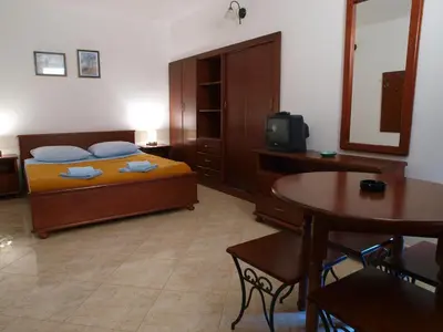 a bedroom with a bed and a table and a tv at Apartments Obala B&B - Dragović in Petrovac na Moru