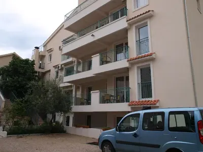a blue car parked in front of a building at Apartments Obala B&B - Dragović in Petrovac na Moru