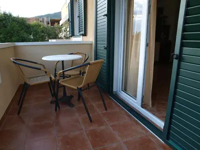 a patio with two chairs and a table on a porch at Apartments Laništa - Dragović in Petrovac na Moru