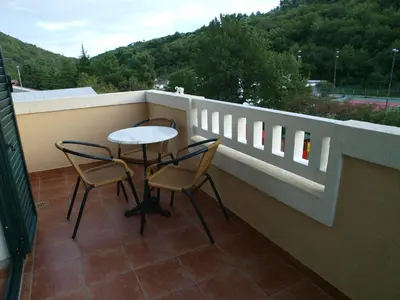 a balcony with two chairs and a table on a balcony at Apartments Laništa - Dragović in Petrovac na Moru