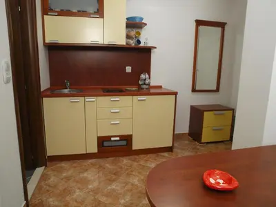 a kitchen with a sink and a table and a mirror at Apartments Laništa - Dragović in Petrovac na Moru