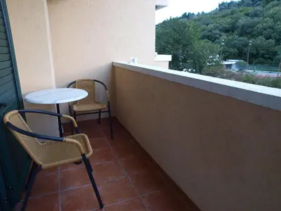 a balcony with two chairs and a table at Apartments Laništa - Dragović in Petrovac na Moru